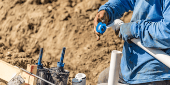 plumper applying PTFE tape to a pipe