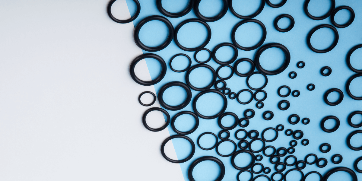 A group of black o rings on a blue and grey background.
